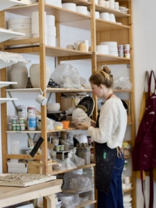 een atelierdeler staat voor de kast waar zij een plank huurt voor haar werk en tools